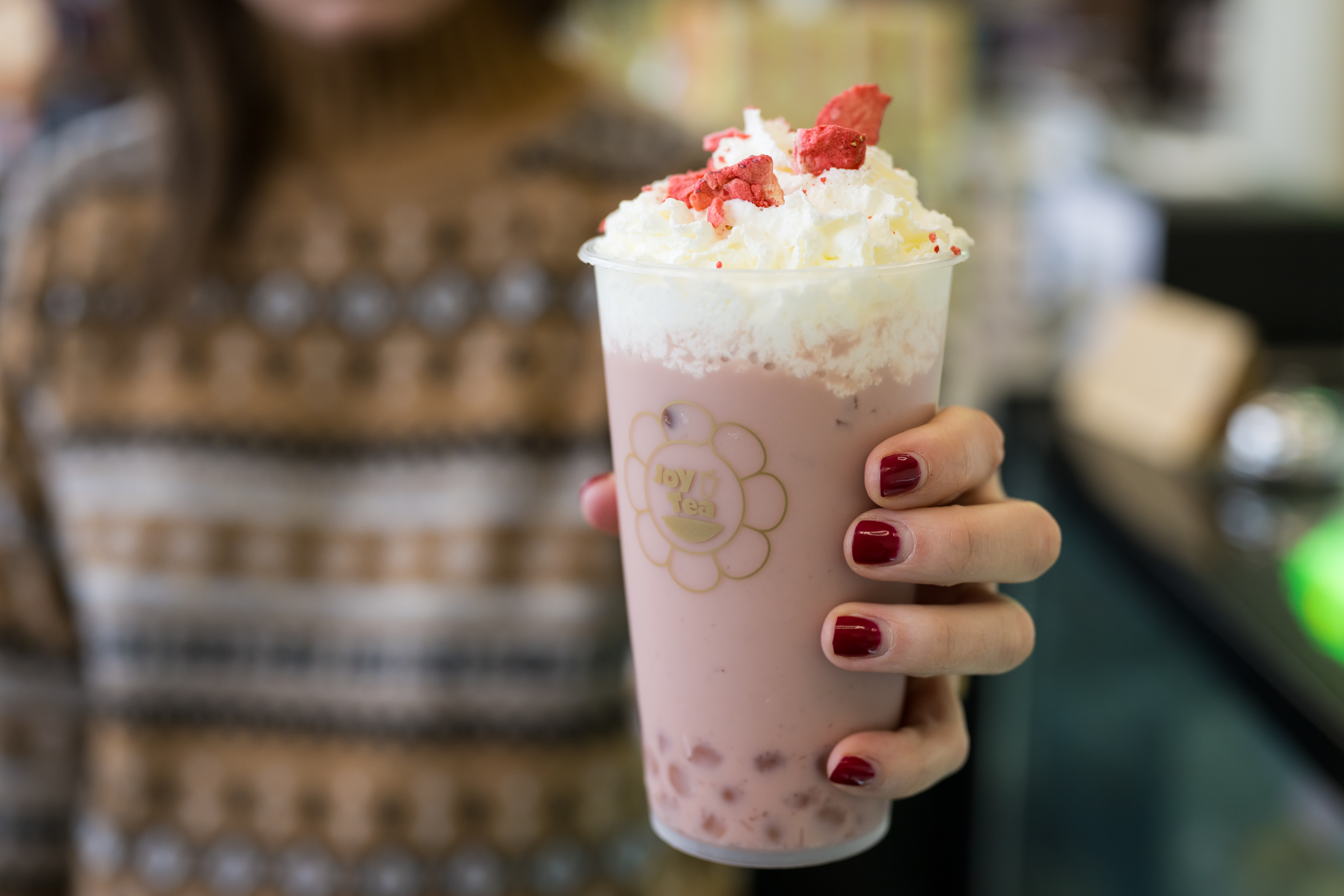A person holding a pink Bubble Tea at JoyMart