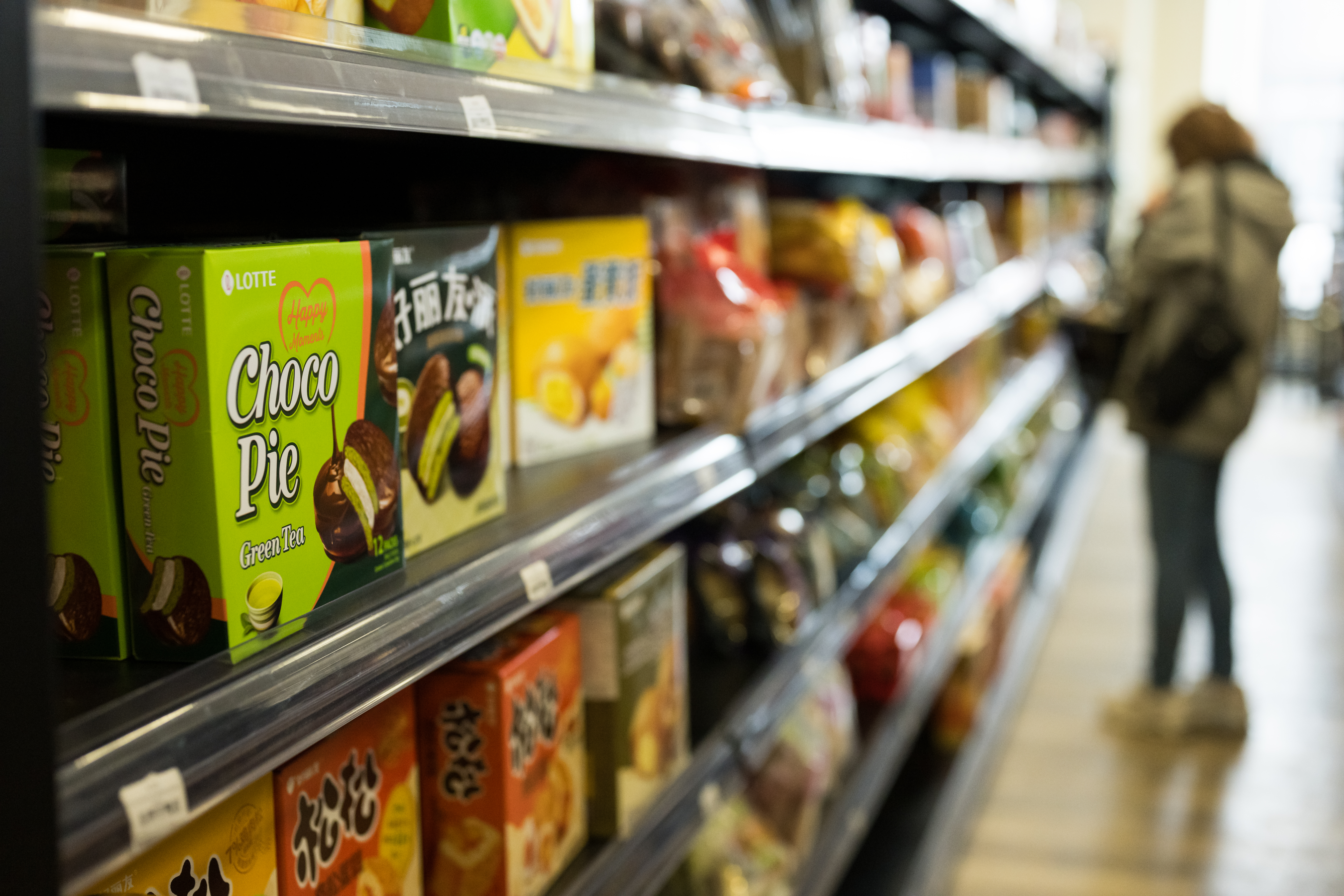A customer standing in the aisle of JoyMart.